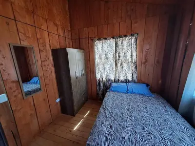 a bedroom with a bed in a wooden cabin at Cabaña Duende Oscuro - Paradise IN THE Mountains! in San Pablo