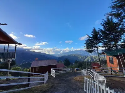 a farm with a fence and mountains in the background at Cabaña Duende Oscuro - Paradise IN THE Mountains! in San Pablo