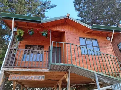 a log cabin with a balcony on top of it at Cabaña Duende Oscuro - Paradise IN THE Mountains! in San Pablo