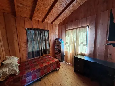 a bedroom with a bed in a wooden cabin at Cabaña Duende Oscuro - Paradise IN THE Mountains! in San Pablo