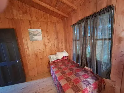 a bedroom with a bed in a log cabin at Cabaña Duende Oscuro - Paradise IN THE Mountains! in San Pablo