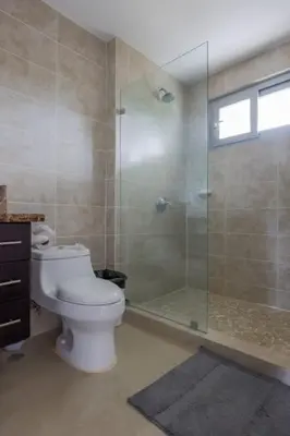 a bathroom with a toilet and a glass shower at Diamante del Sol 303S- 3rd Floor Ocean View in Jacó