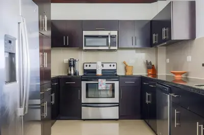 a kitchen with black cabinets and stainless steel appliances at Diamante del Sol 303S- 3rd Floor Ocean View in Jacó