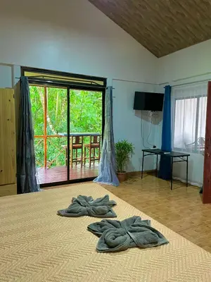 a room with two towels on a bed with a window at Cabañas el Bosque del Arenal in Guayabal