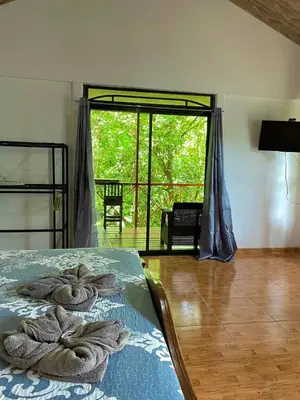 a bedroom with a bed with towels on it at Cabañas el Bosque del Arenal in Guayabal