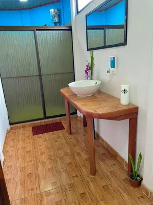 a bathroom with a bowl sink on a wooden table at Cabañas el Bosque del Arenal in Guayabal
