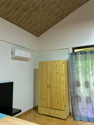 a bedroom with a bed and a wooden cabinet at Cabañas el Bosque del Arenal in Guayabal