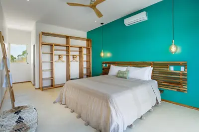 a bedroom with a large bed and a blue wall at Stylish ocean view Villa Blume at Hermosa Hills in Playa hermosa