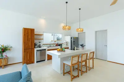 a kitchen with a counter and chairs in a room at Stylish ocean view Villa Blume at Hermosa Hills in Playa hermosa
