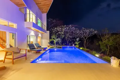 a swimming pool in the backyard of a house at night at Stylish ocean view Villa Blume at Hermosa Hills in Playa hermosa