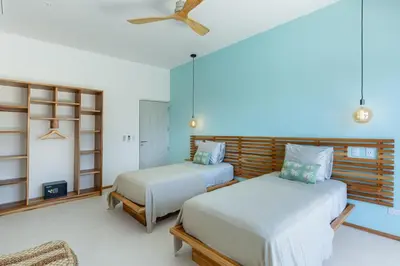 a bedroom with two beds and a ceiling fan at Stylish ocean view Villa Blume at Hermosa Hills in Playa hermosa