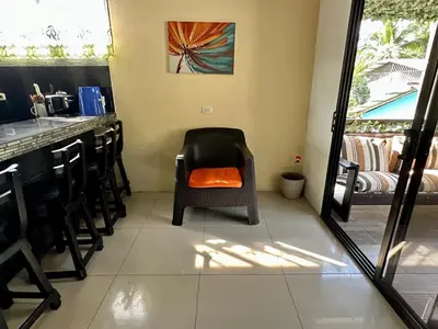 a room with a chair with an orange pillow on it at Beautiful View House in Tortuguero