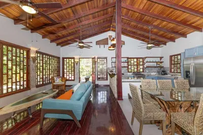 a living room with a blue couch and a table at Restful Casa Quetzal Luxurious Rainforest Retreat in Quepos