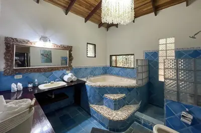 a blue bathroom with a tub and a sink at Restful Casa Quetzal Luxurious Rainforest Retreat in Quepos