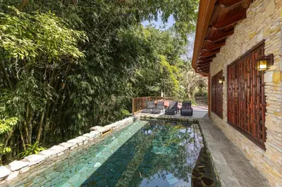 a swimming pool in the side of a house at Restful Casa Quetzal Luxurious Rainforest Retreat in Quepos