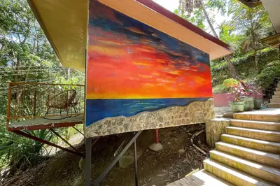 a painting on a wall next to a staircase at Restful Casa Quetzal Luxurious Rainforest Retreat in Quepos