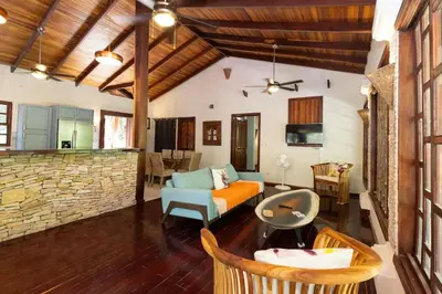 a living room with a couch and a stone wall at Restful Casa Quetzal Luxurious Rainforest Retreat in Quepos