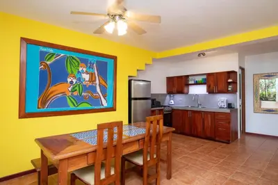 a dining room with a table and a kitchen at 2BR Eco Condo 1 AC 5MINS to Medical Center in Quepos