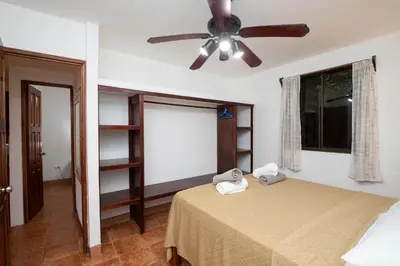 a bedroom with a bed with a ceiling fan at 2BR Eco Condo 1 AC 5MINS to Medical Center in Quepos