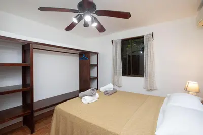a bedroom with a bed with a ceiling fan at 2BR Eco Condo 1 AC 5MINS to Medical Center in Quepos