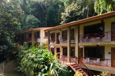 a building with a staircase in front of a forest at Cozy 2BR EcoCondo 3 w Free Security WiFi in Quepos