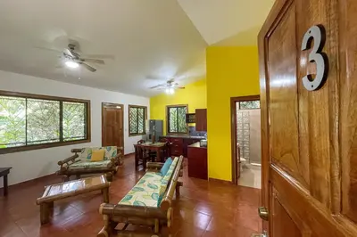 a living room with yellow walls and wooden floors at Cozy 2BR EcoCondo 3 w Free Security WiFi in Quepos