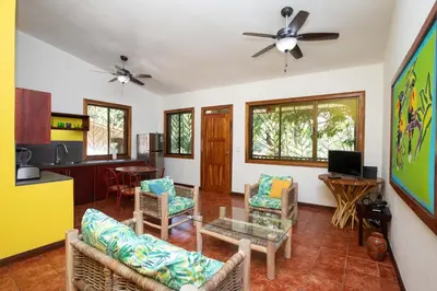 a living room with chairs and a table and a ceiling fan at Cozy 2BR EcoCondo 3 w Free Security WiFi in Quepos