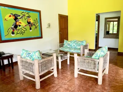 a room with chairs and a table and a painting at Cozy AC EcoCondo 4 with Pool Wildlife Visits in Quepos
