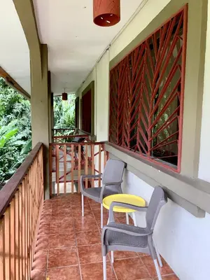 a balcony of a hotel with chairs and tables at Cozy AC EcoCondo 4 with Pool Wildlife Visits in Quepos