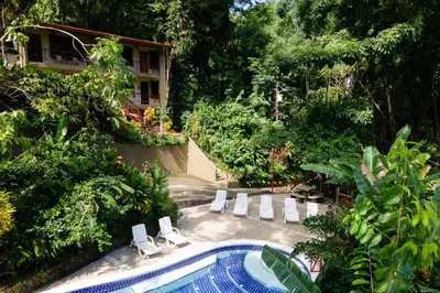 a swimming pool with lounge chairs and a resort at EcoCondo 5 in Secured Community Paradise w pool in Quepos