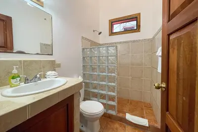 a bathroom with a sink and a toilet and a shower at EcoCondo 5 in Secured Community Paradise w pool in Quepos