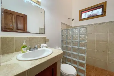 a bathroom with a sink and a toilet at EcoCondo 5 in Secured Community Paradise w pool in Quepos