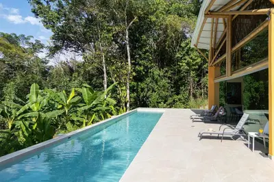 a swimming pool in front of a house at Brand New Villa Bambú with large pool near MA in Quepos