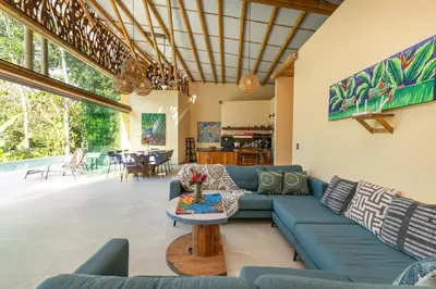 a living room with a blue couch and a table at Brand New Villa Bambú with large pool near MA in Quepos