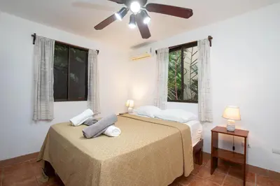 a bedroom with two beds and a ceiling fan at 2BR EcoCondo 2 Terrace wildlife visits in Quepos
