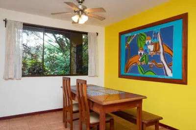 a dining room with a table and a painting on the wall at 2BR EcoCondo 2 Terrace wildlife visits in Quepos