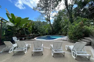 a group of lawn chairs and a swimming pool at 2BR EcoCondo 2 Terrace wildlife visits in Quepos