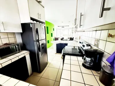 a kitchen with a black refrigerator and white cabinets at Casa Matiza, 7 min SJO airport, free parking, AC in Santiago Este