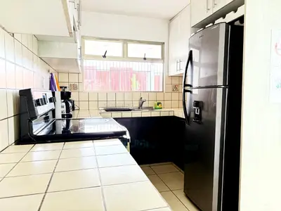 a kitchen with a black refrigerator and a sink at Casa Matiza, 7 min SJO airport, free parking, AC in Santiago Este
