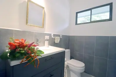 a bathroom with a sink and a toilet and a mirror at Casa Mari Black Stallion in Tamarindo