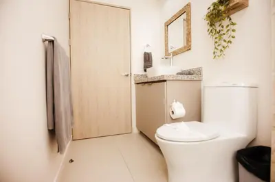 a white bathroom with a toilet and a mirror at El Prado: New 2br Condo in Las Catalinas in Playa Danta