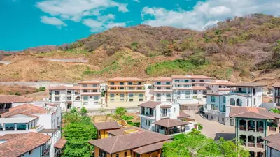 a town in front of a mountain at El Prado: New 2br Condo in Las Catalinas in Playa Danta