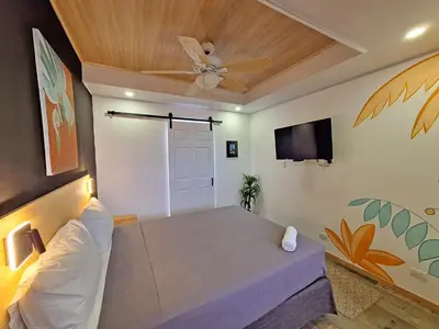 a room with a bed and a ceiling fan at Jungla Urbana, BnB Adult Only in Pavas