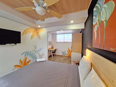 a bedroom with a bed and a ceiling fan at Jungla Urbana, BnB Adult Only in Pavas