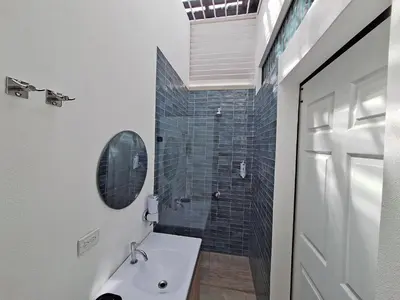 a bathroom with a white sink and a shower at Jungla Urbana, BnB Adult Only in Pavas