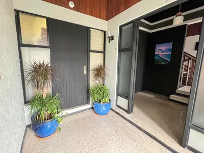 two potted plants sitting on the front porch of a house at Jungla Urbana, BnB Adult Only in Pavas