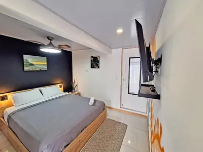 a bedroom with a bed and a flat screen tv at Jungla Urbana, BnB Adult Only in Pavas