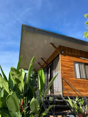 a house with a wooden facade and some plants at Cabaña privada cerca de Manuel Antonio in Parrita