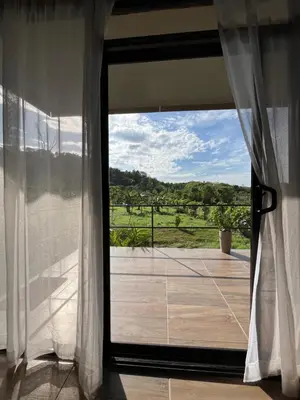 a sliding glass door to a balcony with a view at Cabaña privada cerca de Manuel Antonio in Parrita
