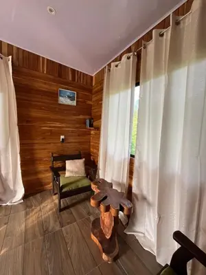 a room with a chair and a table and a window at Cabaña privada cerca de Manuel Antonio in Parrita